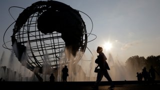 In this Aug. 27, 2018, file photo, a woman walks by a fountain outside of the Billie Jean King Tennis National Center during the first round of the U.S. Open tennis tournament in New York.