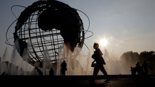In this Aug. 27, 2018, file photo, a woman walks by a fountain outside of the Billie Jean King Tennis National Center during the first round of the U.S. Open tennis tournament in New York.