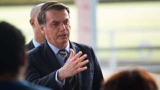 President of Brazil Jair Bolsonaro talks to supporters of his government who waited for him outside the Palácio do Alvorada amidst the coronavirus (COVID-19) pandemic on May 6, 2020 in Brasilia.