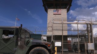 A humvee passes the guard tower guard tower at the entrance of the U.S. prison at Guantanamo Bay, also known as "Gitmo" on October 23, 2016 at the U.S. Naval Station at Guantanamo Bay, Cuba.
