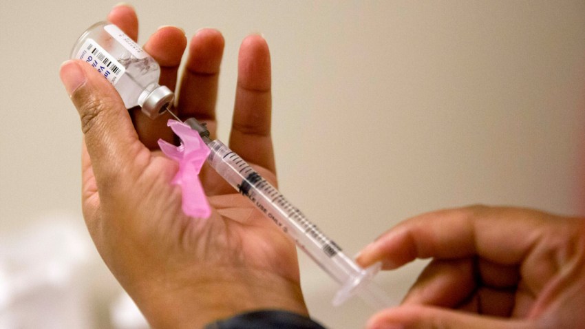 Flu vaccine being drawn from a vial into a syringe.