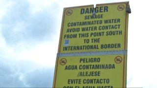 A sign warns beachgoers of contaminated water due to sewage, Oct. 25, 2019.