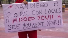 A cosplayer holds up a sign with a message for out-of-towners unable to show their love for Comic-Con International in person due to the coronavirus pandemic.