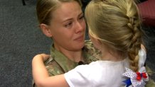 Addison Thomas, 4, and her mom, Army Corporal Brittnee Tiffin, hug during a surprise reunion at the child's school in Santee on July 13, 2020.