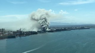 From a distance, smoke is seen coming from USS Bonhomme Richard on Sunday, July 13, 2020.