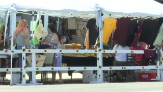 Merchants at a booth sell their items at Barrio Logan's Walk the Block initiative on Saturday, Aug. 9, 2020.