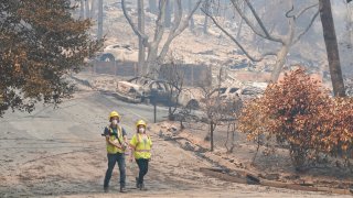 Workers with Davey Resource Group asess the damage to the trees in a neighborhood Tuesday, Aug. 25, 2020, in Boulder Creek, Calif., after the the CZU August Lightning Complex Fire passed by.