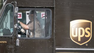 A United Parcel Service (UPS) driver wearing protective mask and gloves makes a delivery in San Francisco, California, U.S., on Monday, May 11, 2020.