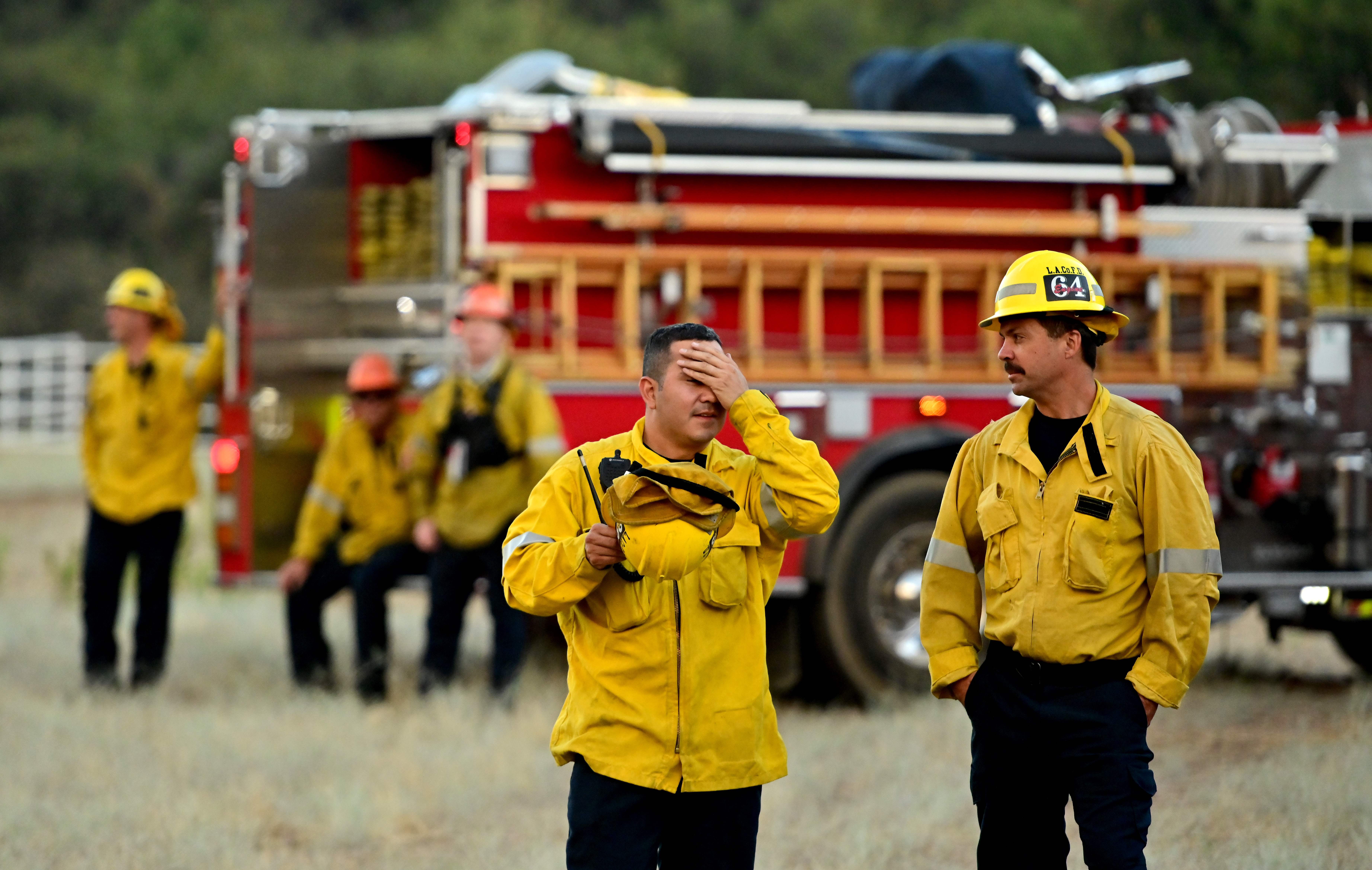 Firefighters wait in an open field as flames make their way across a hillside during the Apple fire near Banning, California on August 1, 2020. – 4,125 acres have burn in Cherry Valley, about 2,000 people have received evacuation orders in the afternoon of August 1.<br />nAround 8PM the fire spread to 12,000 acres. (Photo by JOSH EDELSON / AFP) (Photo by JOSH EDELSON/AFP via Getty Images)