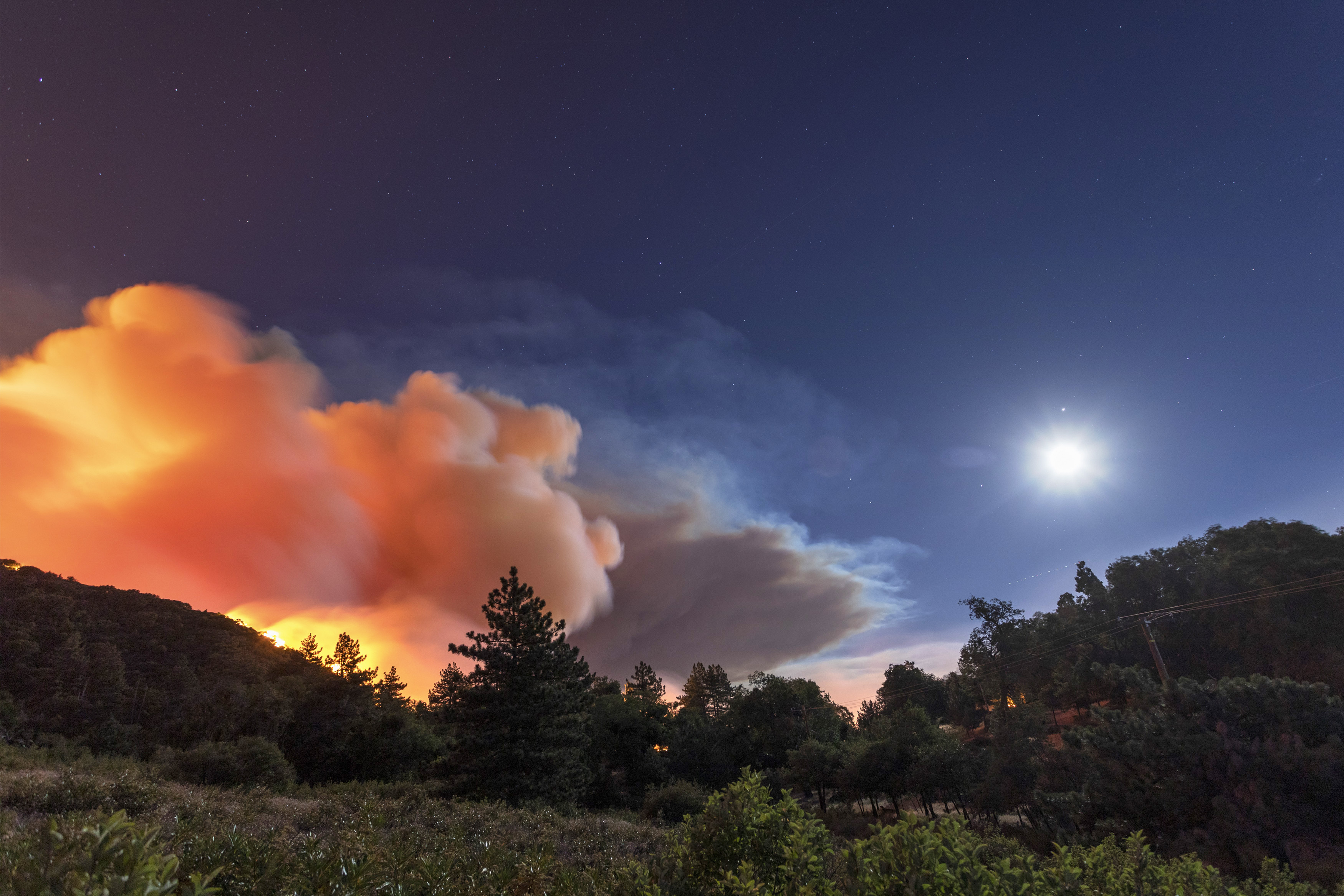 CHERRY VALLEY, CA – AUGUST 01: Flames approach on a western front of the Apple Fire, consuming brush and forest under a nearly full moon during an excessive heat warning on August 1, 2020 in Cherry Valley, California. The fire began shortly before 5 p.m. the previous evening, threatening a large number of homes overnight and forcing thousands to flee before exploding to 12,000 acres this afternoon, mostly climbing the steep wilderness slopes of the San Bernardino Mountains.  (Photo by David McNew/Getty Images)