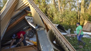 People clear debris from a damaged garage after Hurricane Laura made landfall in Orange, Texas, U.S., on Thursday, Aug. 27, 2020. Hurricane Laura raked across Louisiana early on Thursday, becoming one of the most powerful storms ever to hit the state with a "catastrophic storm surge," flash floods and devastating winds that could inflict more than $15 billion in insured losses.