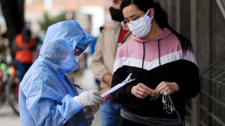 A nurse takes personal information from a woman before a COVID-19 test on July 19, 2020 in Bogota, Colombia. According to World Health Organization, Colombia has registered over 190,700 positive cases of Coronavirus (COVID-19) and more than 6,500 deaths.