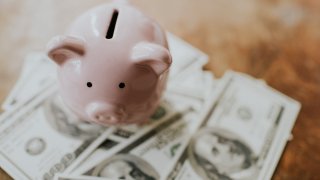 American $100 bank notes around a piggy bank.