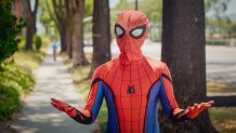 A person in a spider-Man costume talks to the camera