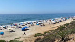 Beachgoers escape the San Diego County heat at Carlsbad State Beach on Saturday, Sept. 5, 2020.