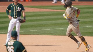 OAKLAND, CALIFORNIA – SEPTEMBER 06: Yusmeiro Petit #36 and Chad Pinder #18 of the Oakland Athletics looks on as Fernando Tatis Jr. #23 of the San Diego Padres trots around the bases after he hit a two-run home run in the top of the seventh inning at RingCentral Coliseum on September 06, 2020 in Oakland, California. (Photo by Thearon W. Henderson/Getty Images)