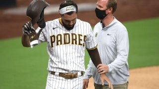 SAN DIEGO, CALIFORNIA – SEPTEMBER 07: Eric Hosmer #30 of the San Diego Padres has his hand looked at by a team trainer after being hit by a pitch during the first inning of a game against the Colorado Rockies at PETCO Park on September 07, 2020 in San Diego, California. Hosmer would leave the game after being hit in the hand. (Photo by Sean M. Haffey/Getty Images)