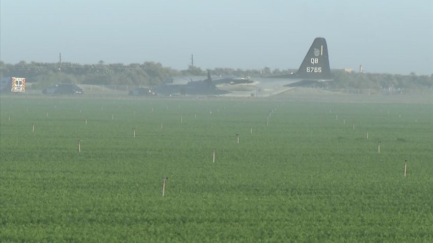 A KC-130J assigned to Marine Corps Air Station Miramar sitting in a field near an airport in Thermal, CA following a mid-air collision with an F-35B