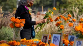 Artist and altar maker Ofelia Esparza, 88, from East Los Angeles, brings fresh marigolds for her community altar for Day of the Dead, titled "2020 Memorial to Our Resilience," at Grand Park in Los Angeles, Thursday, Oct. 29, 2020.