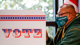 In this Oct. 20, 2020, file photo, a man casts his ballot at Tippecanoe Library on the first day of in-person early voting for the November 3rd elections in Milwaukee, Wisconsin.