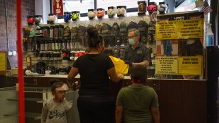 Gil Kimmelman, owner of Continental Dry Goods, checks out customers buying clothes on October 24, 2020 in El Paso, Texas.