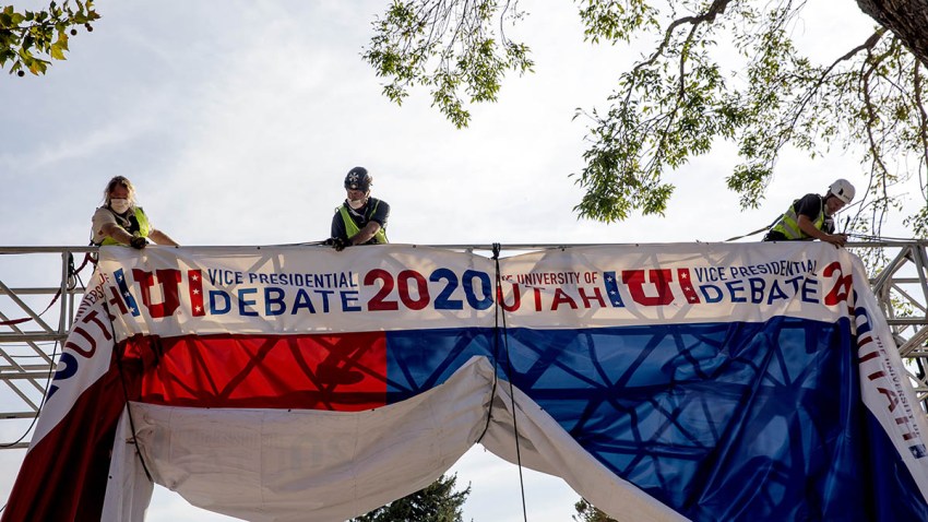 Workers hang banners outside of Kingsbury Hall on the University of Utah campus ahead of the U.S. vice presidential debate in Salt Lake City, Utah, Oct. 5, 2020.