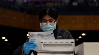 San Francisco Department of Elections worker Rosy Chan checks for damaged ballots at a voting center in San Francisco, Sunday, Nov. 1, 2020.