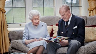 Britain's Queen Elizabeth II and Prince Philip, Duke of Edinburgh look at a homemade wedding anniversary card, given to them by their great grandchildren Prince George, Princess Charlotte and Prince Louis, as the royal couple sit in the Oak Room at Windsor Castle