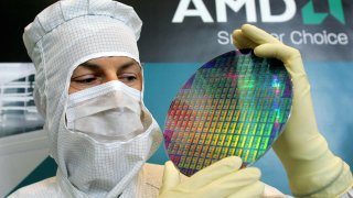 A worker holding a wafer at Advanced Micro Devices