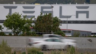 Vehicles pass the Tesla Inc. assembly plant in Fremont, California, U.S., on Monday, May 11, 2020.