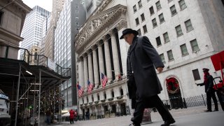 A pedestrian walks along Wall Street in front of the New York Stock Exchange (NYSE) in New York, Dec. 9, 2020.
