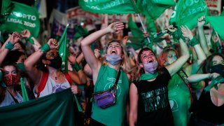 Abortion-rights activists watch live video streaming of lawmakers in session, outside Congress in Buenos Aires, Argentina, Wednesday, Dec. 30, 2020. Congress approved a bill that legalize abortion in Argentina.