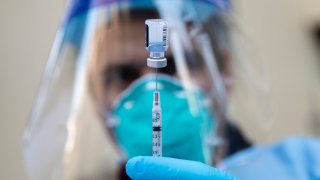 Marin County Fire medic Kevin Stone prepares a dose of the Pfizer COVID-19 vaccine.