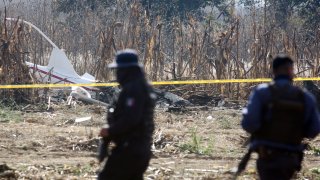 Members of the Federal Police search the scene on December 25, 2018 of a helicopter crash in which the governor of the Mexican state of Puebla, Martha Erika Alonso, and her husband, senator and former governor of the same region, Rafael Moreno, died on December 24 when the chopper plummeted to the ground in San Pedro Tlaltenango after taking off from the nearby city of Puebla.