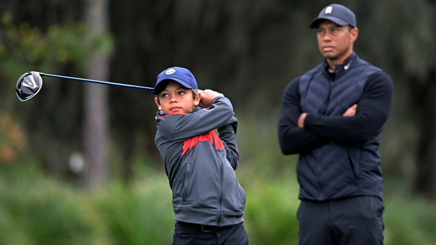 Tiger Woods, right, watches as his son Charlie tees off on the 12th hole during a practice round of the Father Son Challenge golf tournament, Thursday, Dec. 17, 2020, in Orlando, Florida.