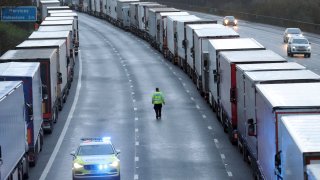 Police patrol along the M20 motorway where freight traffic is parked whilst the Port of Dover remains closed, in Ashford, Kent, England, Tuesday, Dec. 22, 2020. Trucks waiting to get out of Britain backed up for miles and people were left stranded at airports as dozens of countries around the world slapped tough travel restrictions on the U.K. because of a new and seemingly more contagious strain of the coronavirus in England.