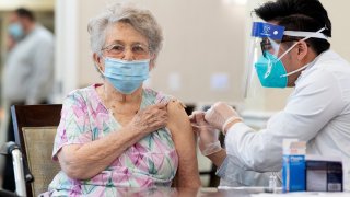 A CVS pharmacist gives the Pfizer/BioNTech COVID-19 vaccine to a resident at the Emerald Court senior living community in Anaheim, CA on Friday, January 8, 2021.