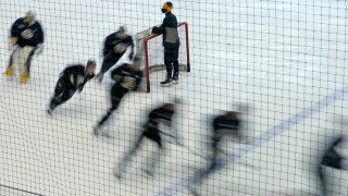 Boston Bruins players skate around a goal during a speed drill at the team's NHL hockey training camp, Monday, Jan. 4, 2021, in Boston.
