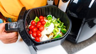 Seasoned vegetables are cooked in an air fryer.