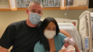Nick and Melissa Hawke with their newborn, Delmar.