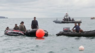 Indonesian Navy divers position their boats near marker buoys as they continue the search for the wreckage of the crashed Sriwijaya Air passenger jet continues in the Java Sea, near Jakarta, Indonesia, Tuesday, Jan. 12, 2021. Indonesian navy divers were searching through plane debris and seabed mud Tuesday looking for the black boxes of a Sriwijaya Air jet that nosedived into the Java Sea over the weekend with 62 people aboard.