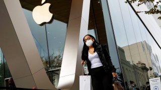 A customer exits after picking up Apple’s new 5G iPhone 12 that went on sale, as the coronavirus disease (COVID-19) outbreak continues, at an Apple Store in Brooklyn, New York, October 23, 2020.