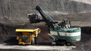 FILE - In this April 4, 2013, file photo, a mechanized shovel loads a haul truck that can carry up to 250 tons of coal at the Spring Creek coal mine near Decker, Mont. The Trump administration says the resumption of coal sales from public lands will result in a negligible increase in greenhouse gas emissions, but critics say that ignores the federal coal programs broader impacts.