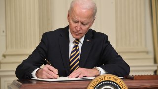 US President Joe Biden signs an executive order on securing critical supply chains, in the State Dining Room of the White House in Washington, DC, February 24, 2021.