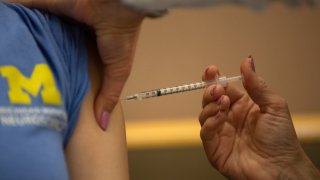 A healthcare worker receives the Pfizer-BioNTech Covid-19 vaccine at the Michigan Medicine facility in Ann Arbor, Michigan, U.S., on Wednesday, Dec. 16, 2020.