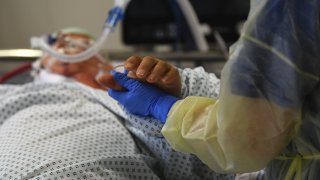 A healthcare worker cares for a Covid-19 patient in the ICU ward at the Robert Bosch Hospital in Stuttgart, Germany, on Tuesday, Jan. 12, 2021.
