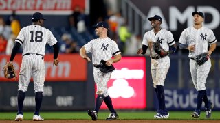 New York Yankees, from left, Didi Gregorius, Brett Gardner, Cameron Maybin, and Giancarlo Stanton celebrate after defeating the Houston Astros