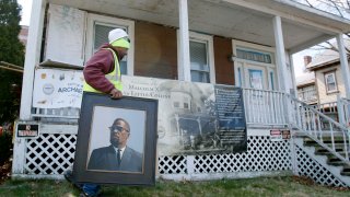 Rodnell P. Collins carries a painting of his uncle, Malcolm X