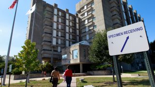 Passers-by approach the William A. Hinton State Laboratory Institute, which houses the Massachusetts state drug lab, in the Jamaica Plain neighborhood of Boston, Thursday, Sept. 27, 2012.