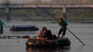 Guatemalan travelers cross the Suchiate River, border between Guatemala and Mexico, into Mexico aboard a raft near Ciudad Hidalgo, Sunday, March 21, 2021. Mexico sent hundreds of immigration agents, police and National Guard officers marching through the streets of the capital of the southern state of Chiapas to launch an operation to crack down on migrant smuggling.